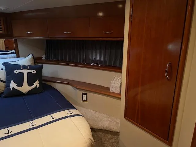 Slide: The Image of Interior of 2005 Carver 46 Motor Yacht with nautical-themed bedding and wooden cabinetry. - 35