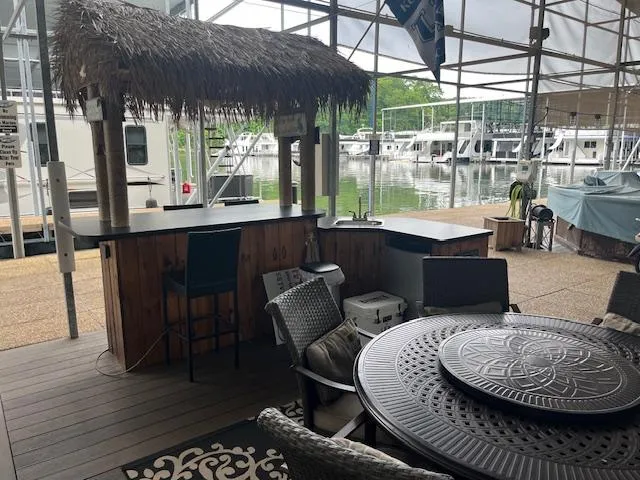 Slide: The Image of Tiki bar setup near a marina with a Carver 46 Motor Yacht, 2005 model. - 43