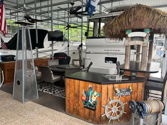 Slide: The Image of 2005 Carver 46 Motor Yacht docked in a marina with a cozy outdoor seating area. - 44