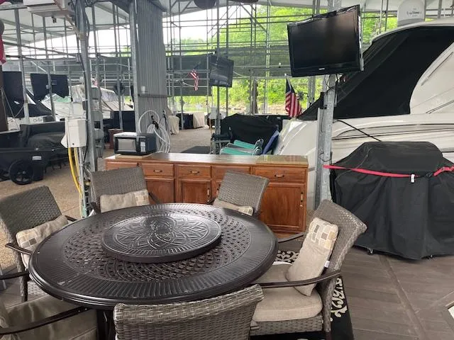 Slide: The Image of Outdoor seating area near a 2005 Carver 46 Motor Yacht, featuring a round table and chairs. - 45