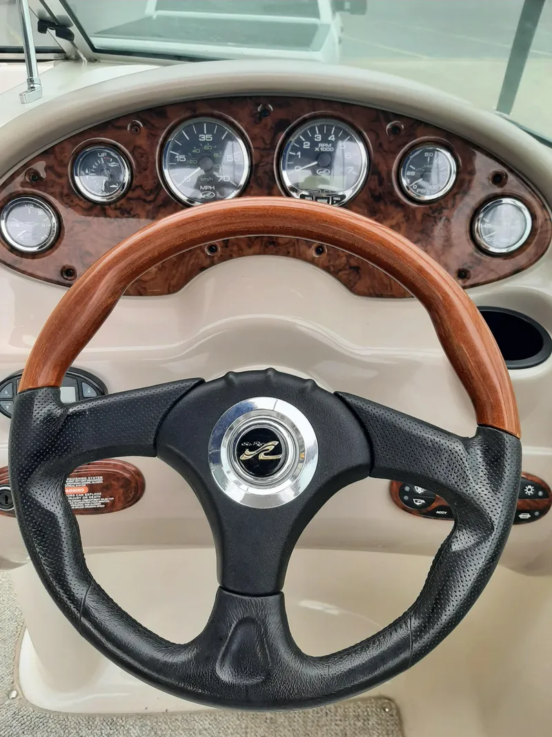 Slide: The Image of 2004 Sea Ray SunDeck 200 dashboard with wood-accented steering wheel and instrument panel. - 4
