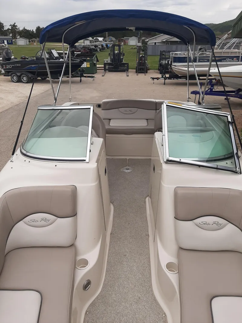Slide: The Image of 2004 Sea Ray SunDeck 200 boat with open seating and blue canopy. - 6