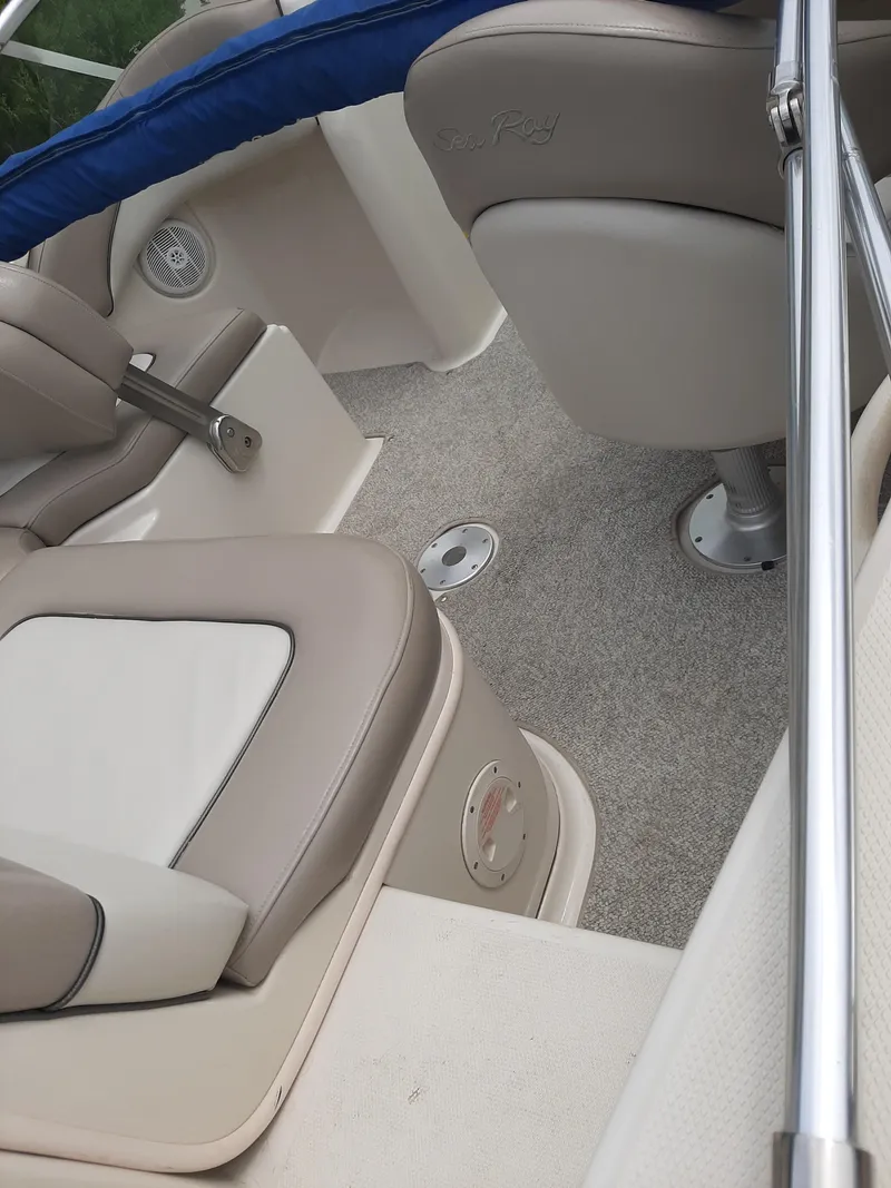 Slide: The Image of 2004 Sea Ray SunDeck 200 interior with beige seating and carpeted flooring. - 7