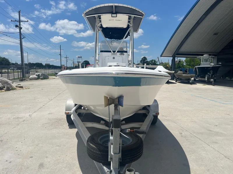 Slide: The Image of 2010 Sea Hunt 21 XP boat on trailer, parked outdoors under a clear blue sky. - 3