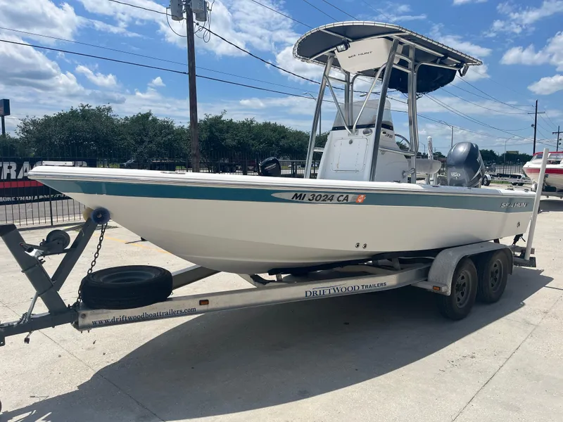 Slide: The Image of 2010 Sea Hunt 21 XP boat on trailer, parked outdoors under a clear sky. - 4