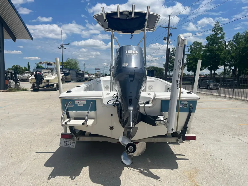 Slide: The Image of 2010 Sea Hunt 21 XP boat with Yamaha 150 engine, parked outdoors. - 6