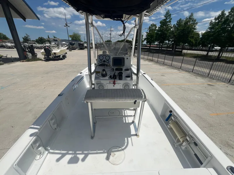 Slide: The Image of 2010 Sea Hunt 21 XP boat interior with console and seating, parked outdoors. - 8