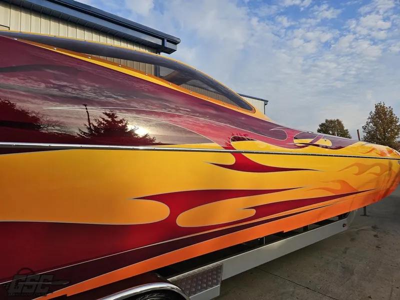 Slide: The Image of 2008 Eliminator 36 Daytona Coupe with vibrant flame design, parked outdoors. - 10