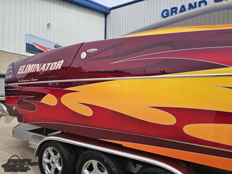 Slide: The Image of 2008 Eliminator 36 Daytona Coupe with vibrant red and yellow flame design on trailer. - 12