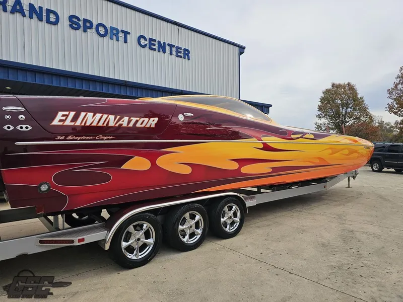 Slide: The Image of 2008 Eliminator 36 Daytona Coupe boat with vibrant flame design on trailer. - 14
