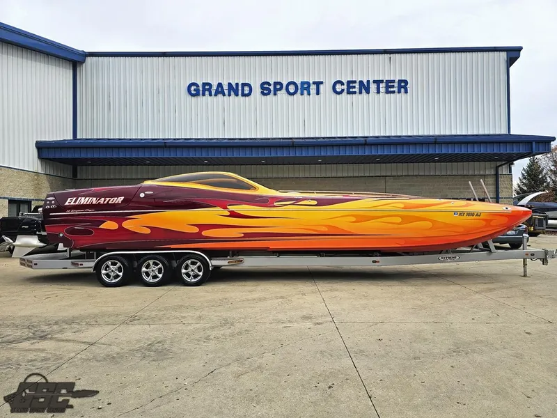 Slide: The Image of 2008 Eliminator 36 Daytona Coupe boat with vibrant flame design at Grand Sport Center. - 23