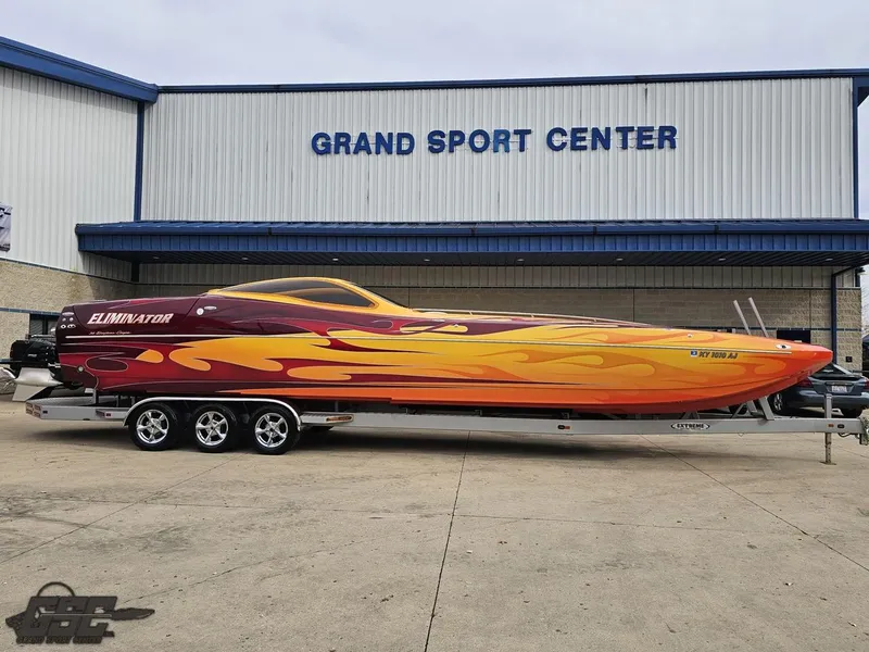 Slide: The Image of 2008 Eliminator 36 Daytona Coupe boat with vibrant flame design at Grand Sport Center. - 24