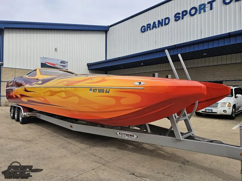 Slide: The Image of 2008 Eliminator 36 Daytona Coupe boat with vibrant flame design on trailer outside Grand Sport Center. - 28