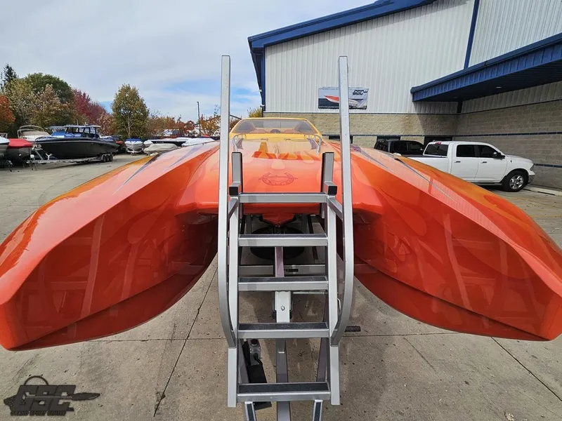 Slide: The Image of Orange 2008 Eliminator 36 Daytona Coupe boat on trailer, parked outside a building. - 30