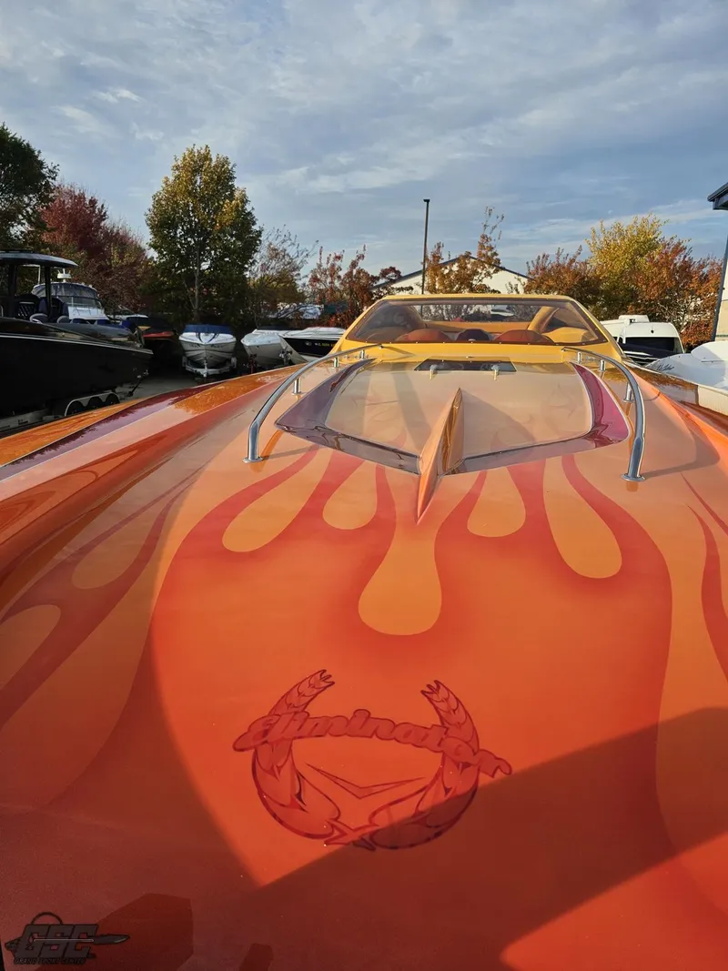 Slide: The Image of 2008 Eliminator 36 Daytona Coupe with vibrant flame design, parked outdoors under a cloudy sky. - 32