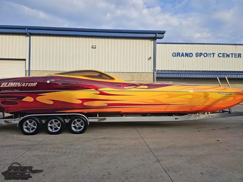 Slide: The Image of 2008 Eliminator 36 Daytona Coupe boat with vibrant flame design at Grand Sport Center. - 4