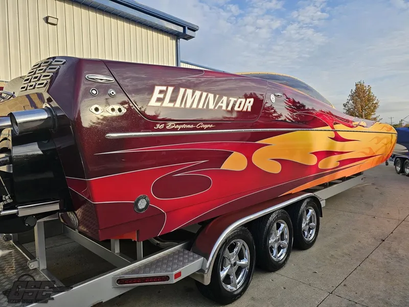 Slide: The Image of 2008 Eliminator 36 Daytona Coupe speedboat with vibrant flame design on trailer. - 49