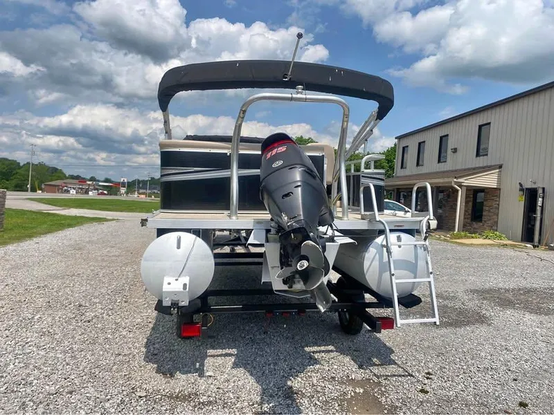 Slide: The Image of 2017 Avalon GS2185 pontoon boat with outboard motor on gravel lot under cloudy sky. - 3