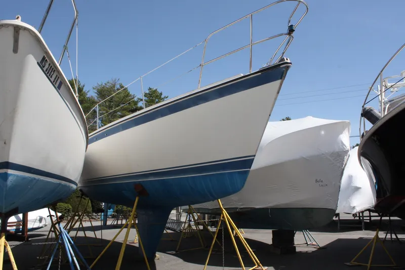 Slide: The Image of 1981 O'Day 34 sailboat on stands, blue and white hull, outdoor storage. - 1