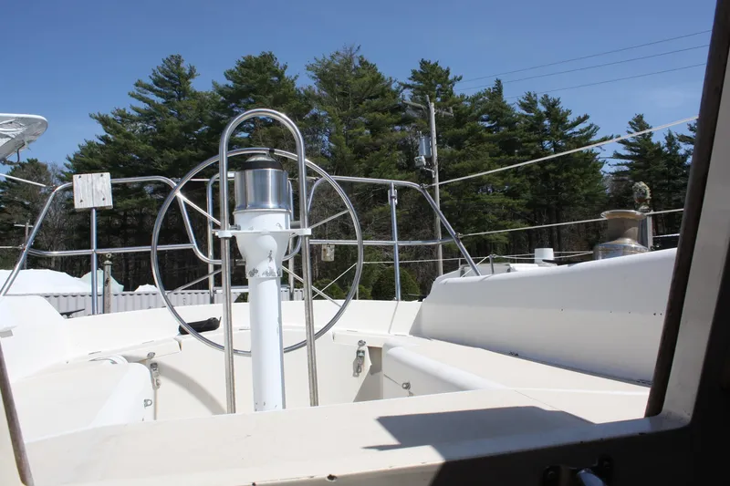 Slide: The Image of 1981 O'Day 34 sailboat cockpit with steering wheel, surrounded by trees. - 14