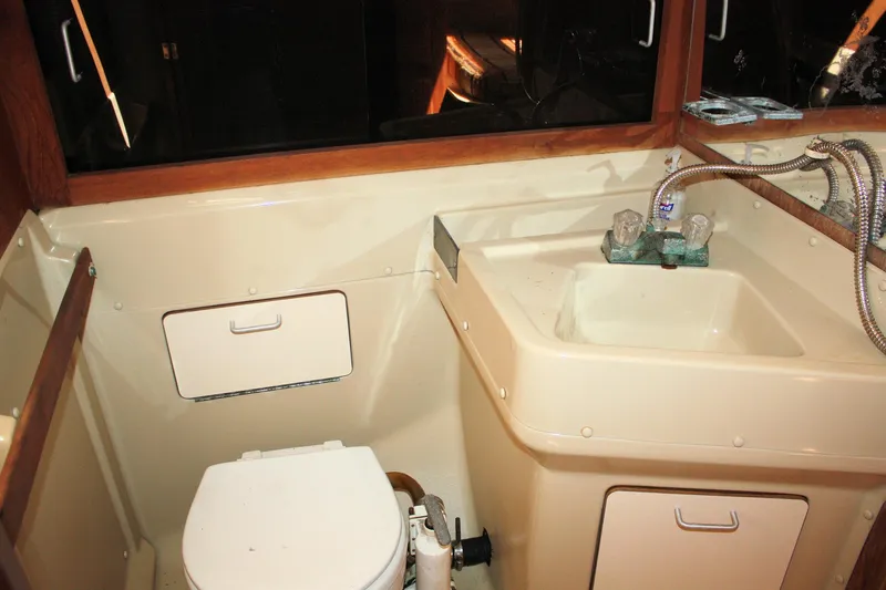 Slide: The Image of 1981 O'Day 34 sailboat bathroom with sink and toilet, featuring compact design and wood accents. - 19