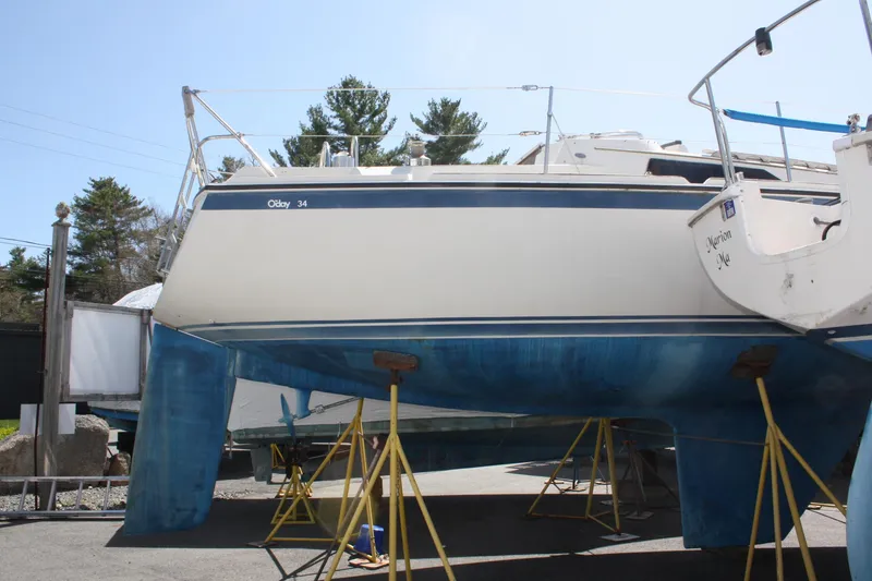 Slide: The Image of 1981 O'Day 34 sailboat on stands, blue hull, outdoor storage. - 2