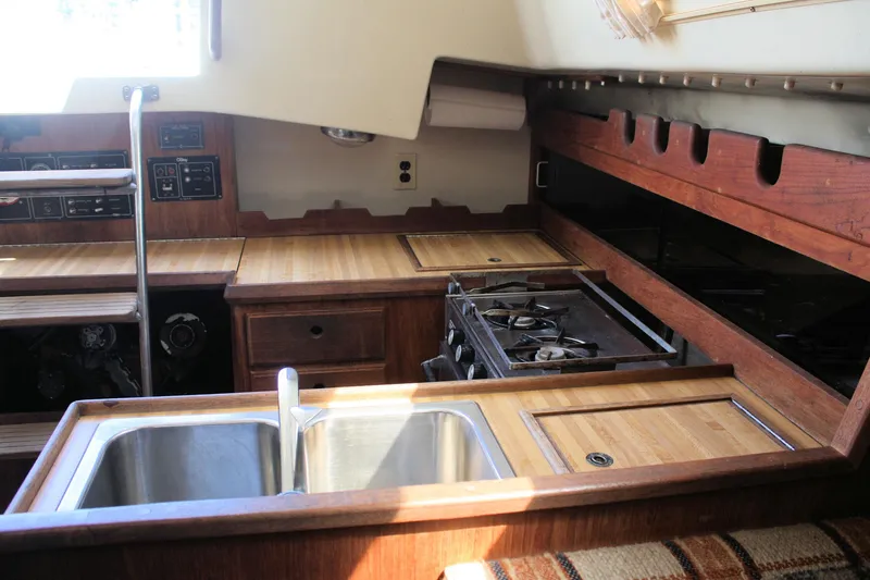Slide: The Image of 1981 O'Day 34 yacht interior kitchen with wooden cabinetry, stove, and dual sink. - 22