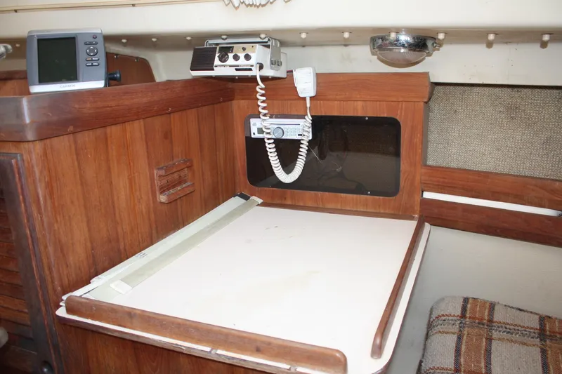 Slide: The Image of 1981 O'Day 34 sailboat interior with navigation equipment and wooden cabinetry. - 27