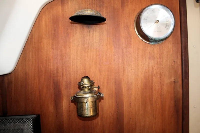 Slide: The Image of Wooden interior of 1981 O'Day 34 sailboat with brass lamp and gauge. - 37