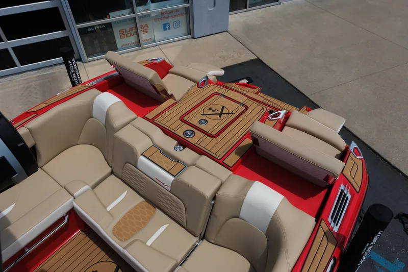 Slide: The Image of 2025 MasterCraft X24 boat interior with red and beige seating, featuring a stylish deck design. - 20