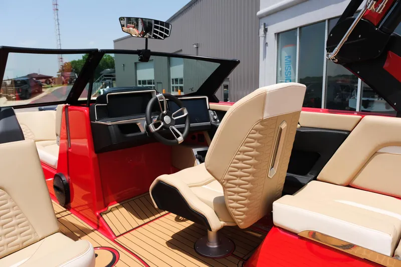 Slide: The Image of 2025 MasterCraft X24 boat interior with red and beige seating, modern dashboard, and steering wheel. - 24