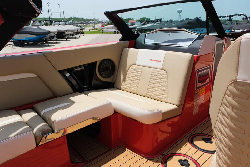 Slide: The Image of 2025 MasterCraft X24 boat interior with beige seating and red accents. - 25
