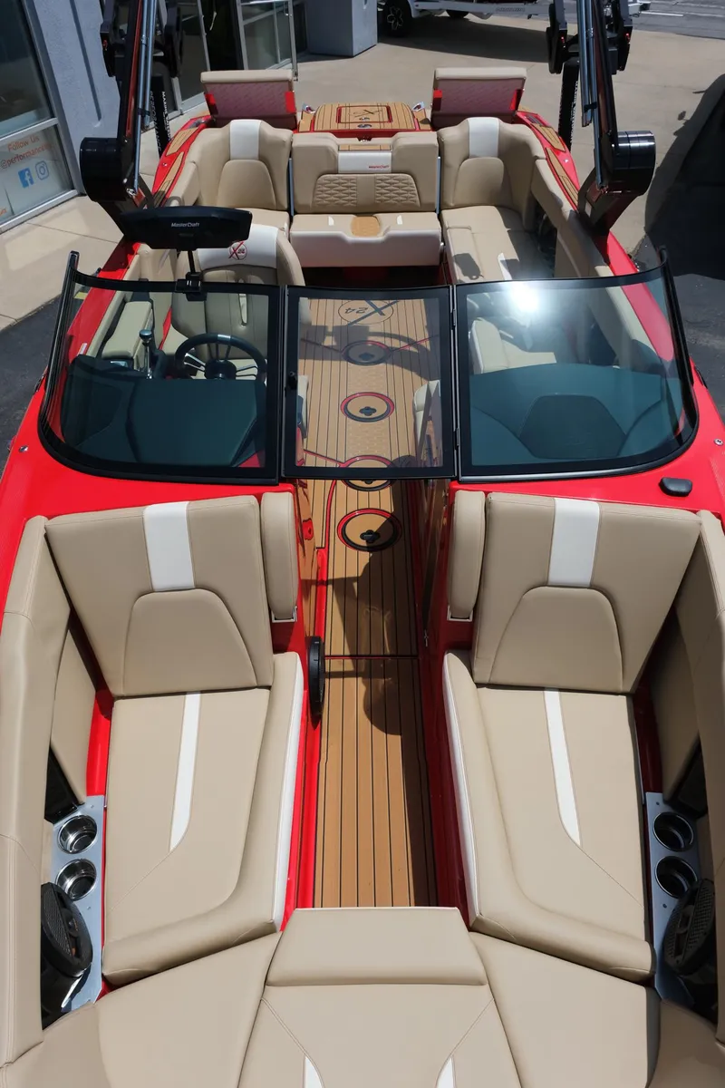 Slide: The Image of 2025 MasterCraft X24 boat interior with beige seating and wood accents. - 27