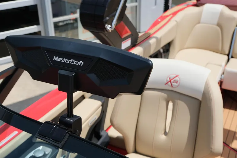 Slide: The Image of 2025 MasterCraft X24 boat interior with beige seating and red accents. - 29