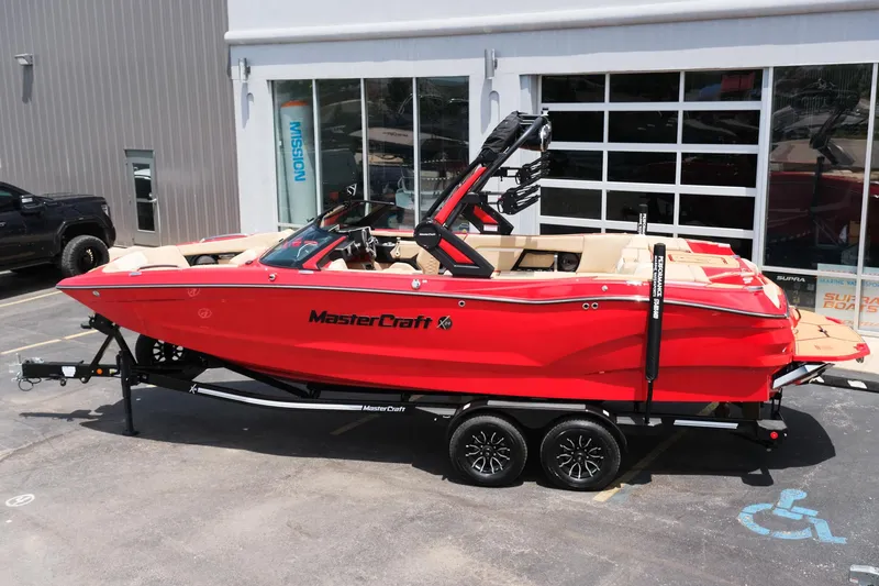 Slide: The Image of 2025 MasterCraft X24 boat in vibrant red, parked on a trailer outside a showroom. - 3
