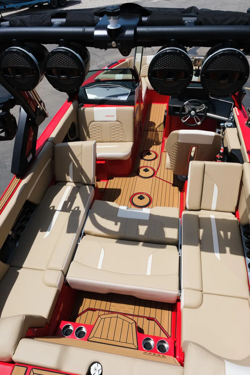 Slide: The Image of 2025 MasterCraft X24 boat interior with beige seating and advanced audio system. - 37