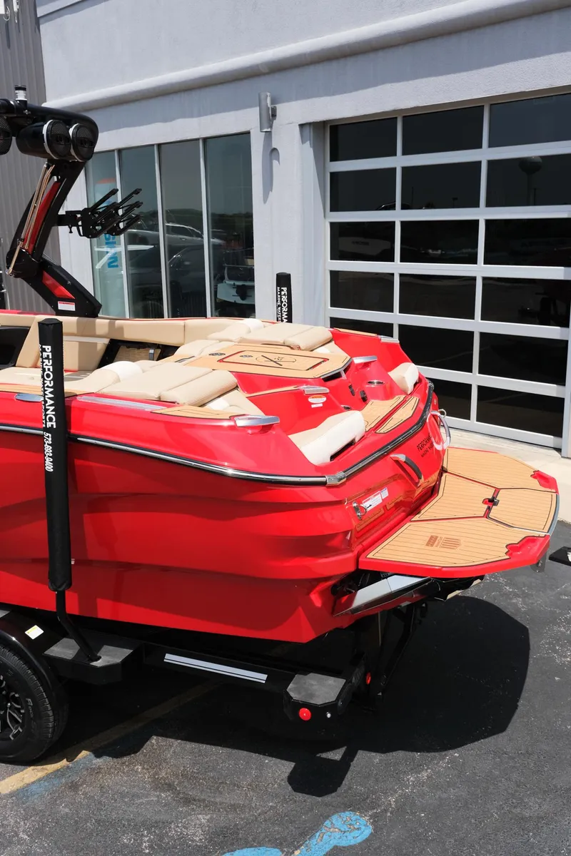 Slide: The Image of 2025 MasterCraft X24 boat in vibrant red, parked outside a modern building. - 6