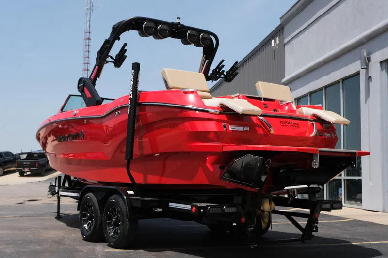 Slide: The Image of 2025 MasterCraft X24 boat in vibrant red on a trailer, parked outdoors. - 9