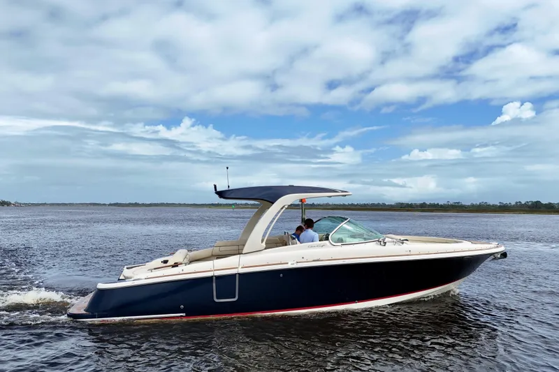 Slide: The Image of 2020 Chris-Craft Launch 31 GT boat cruising on open water under a partly cloudy sky. - 104