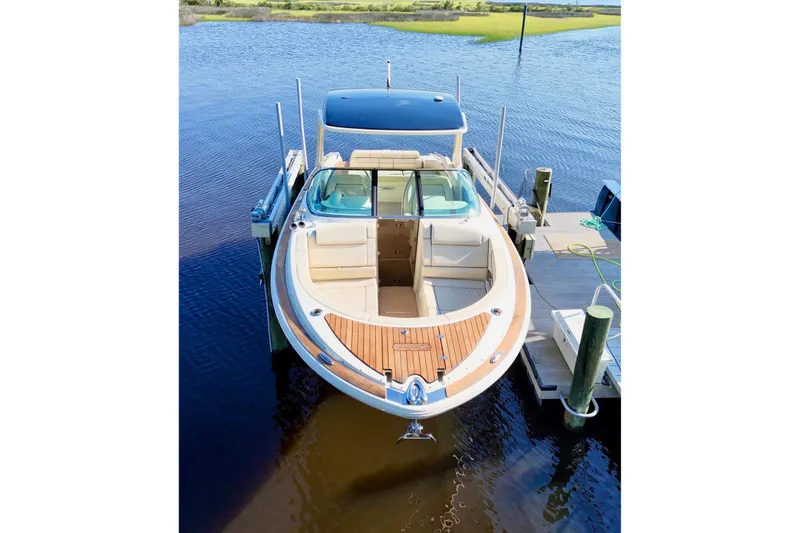 Slide: The Image of 2020 Chris-Craft Launch 31 GT boat on calm water under a blue sky. - 19
