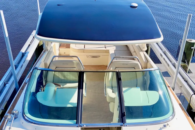 Slide: The Image of 2020 Chris-Craft Launch 31 GT boat cruising on a scenic river under a cloudy sky. - 22