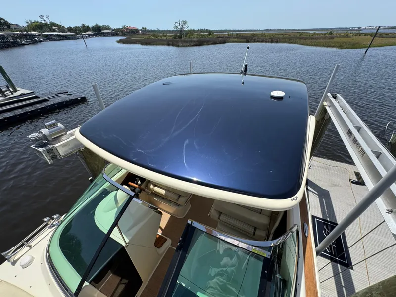 Slide: The Image of 2020 Chris-Craft Launch 31 GT cruising on water near a bridge, rear view. - 23