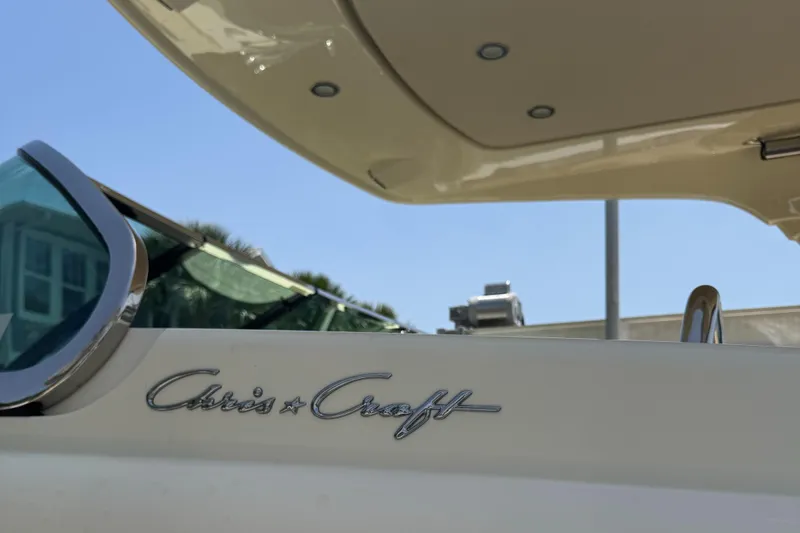 Slide: The Image of 2020 Chris-Craft Launch 31 GT boat docked on a lift by the water. - 27