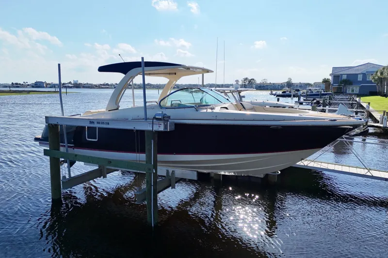 Slide: The Image of 2020 Chris-Craft Launch 31 GT cruising on a scenic waterway under a cloudy sky. - 4