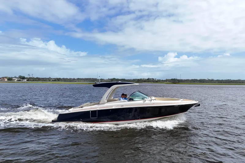 Slide: The Image of 2020 Chris-Craft Launch 31 GT cruising on a calm lake under a partly cloudy sky. - 97