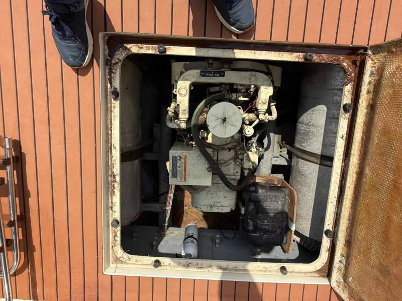 Slide: The Image of Engine compartment of a 1985 Trojan F36 boat, showing mechanical components and deck surface. - 17