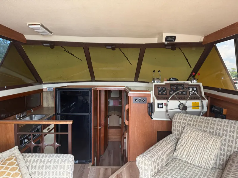 Slide: The Image of Interior of a 1985 Trojan F36 boat with helm, seating, and kitchenette. - 18