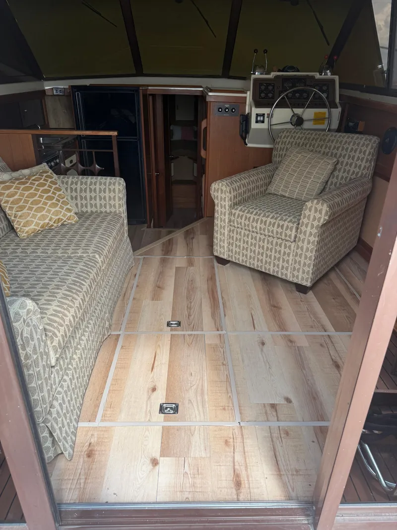 Slide: The Image of Interior of a 1985 Trojan F36 boat with patterned seating and wooden flooring. - 19