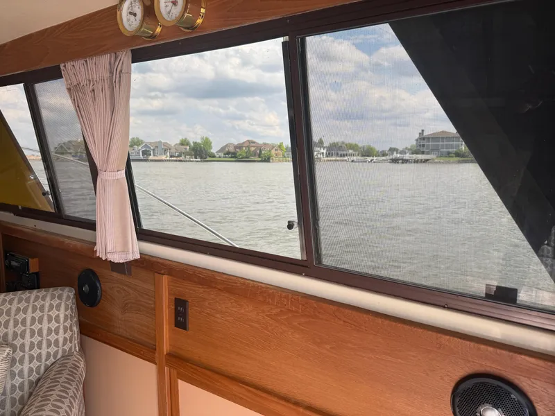 Slide: The Image of Interior view of 1985 Trojan F36 boat with lake scenery through windows. - 23