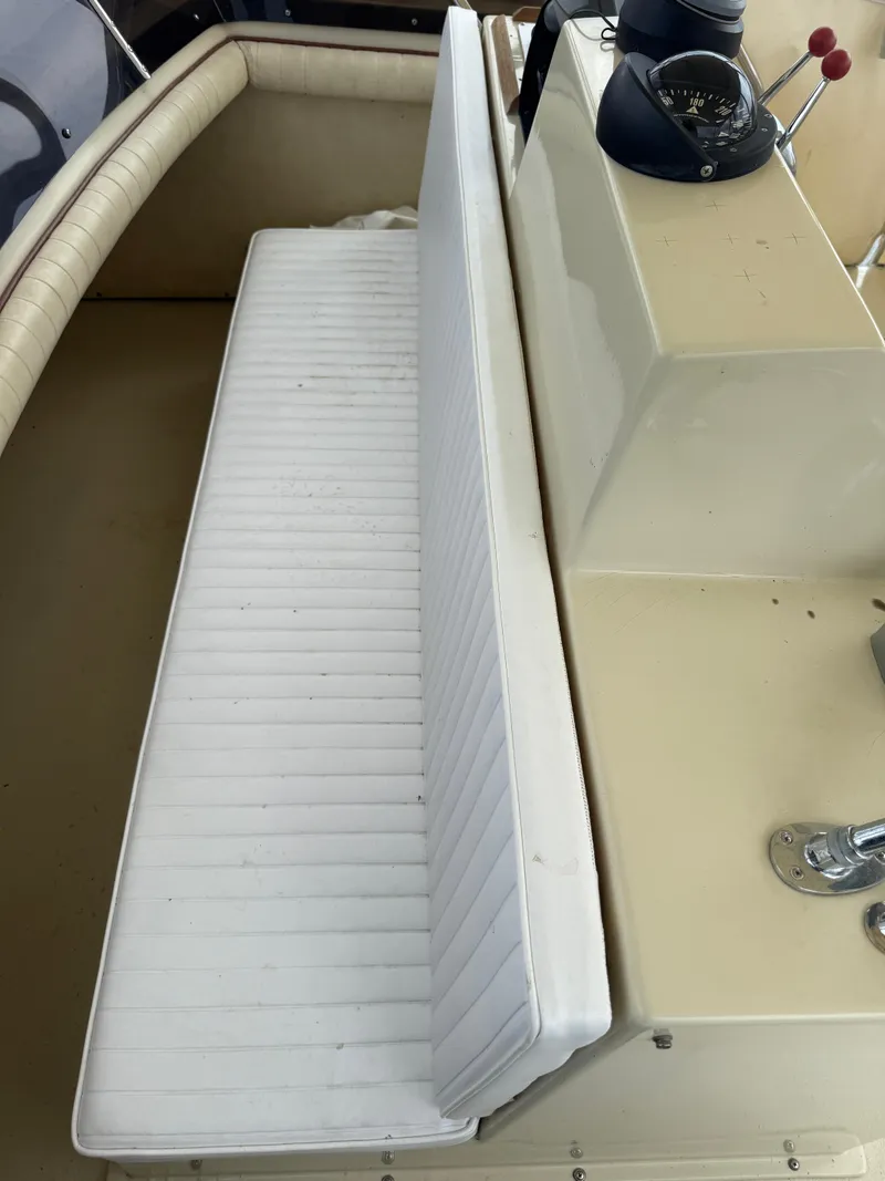 Slide: The Image of 1985 Trojan F36 boat interior with white cushioned seating and control panel. - 29